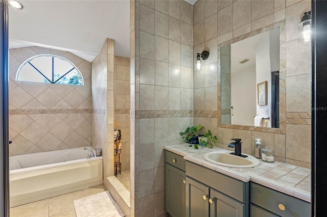 bathroom featuring shower with separate bathtub, tile walls, decorative backsplash, vanity, and tile patterned floors