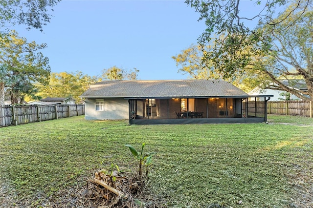 rear view of house featuring a sunroom and a yard