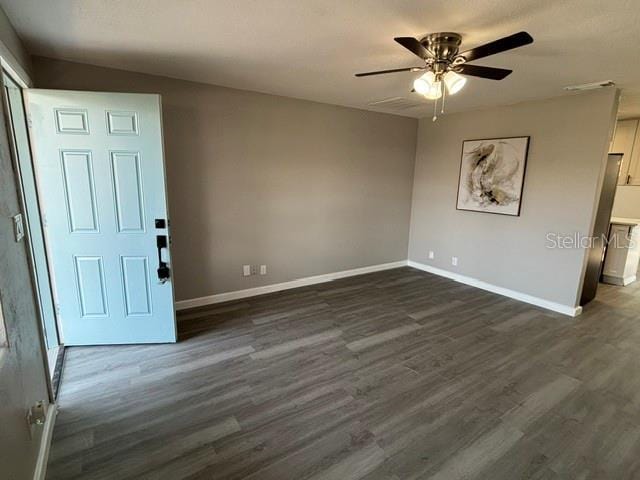 unfurnished room with dark hardwood / wood-style floors and ceiling fan