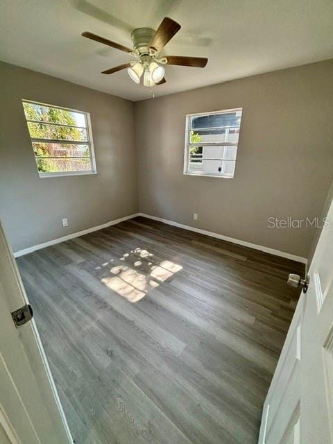 unfurnished room with ceiling fan, plenty of natural light, and dark hardwood / wood-style flooring