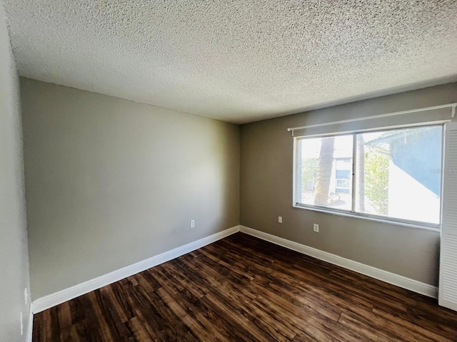 unfurnished room featuring dark hardwood / wood-style floors and a textured ceiling