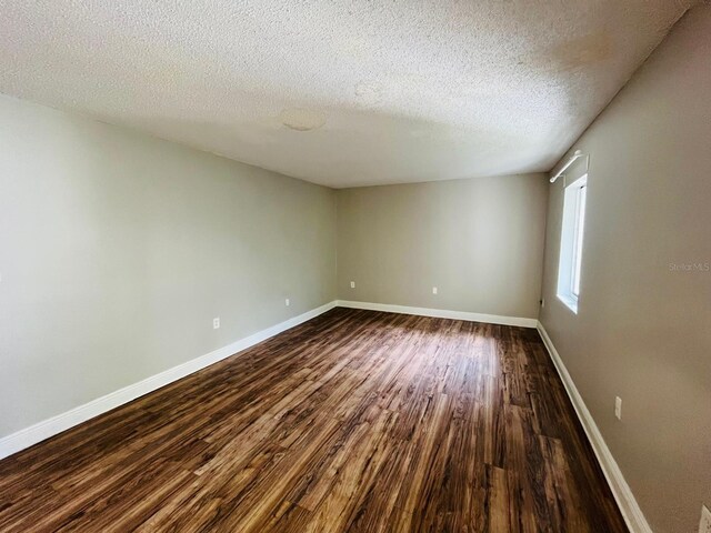 unfurnished room with wood-type flooring and a textured ceiling