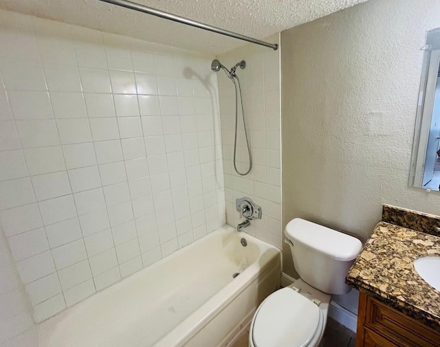 full bathroom featuring vanity, tiled shower / bath, toilet, and a textured ceiling