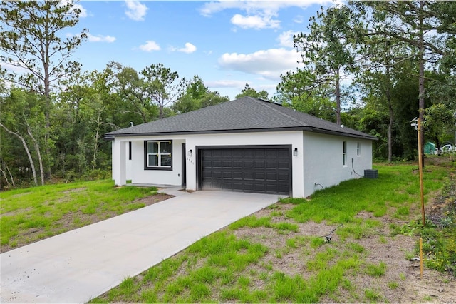 view of front of home with a garage, central AC, and a front yard