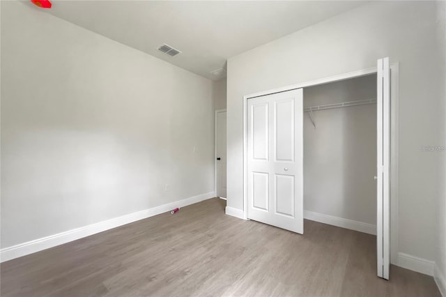 unfurnished bedroom featuring light hardwood / wood-style floors and a closet