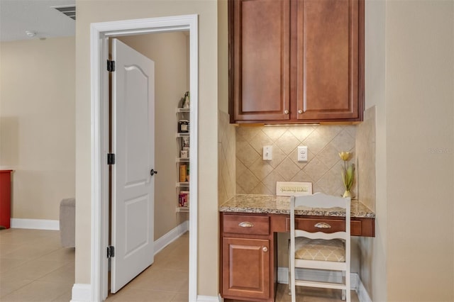 kitchen with light stone counters, light tile patterned flooring, and tasteful backsplash