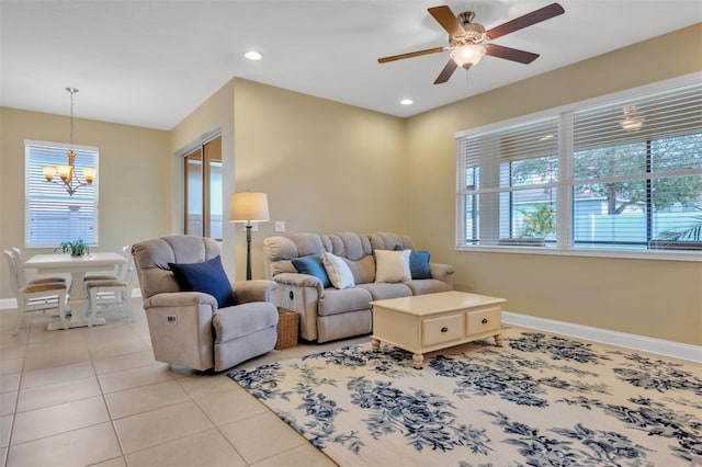 living room featuring ceiling fan with notable chandelier and light tile patterned floors