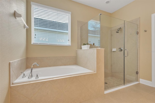 bathroom with independent shower and bath and tile patterned flooring