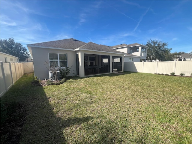 back of property with central AC and a lawn