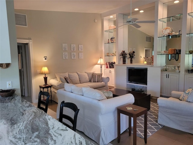 living room featuring built in shelves and ceiling fan