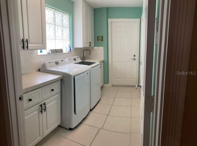 laundry room featuring cabinets, light tile patterned flooring, separate washer and dryer, and sink