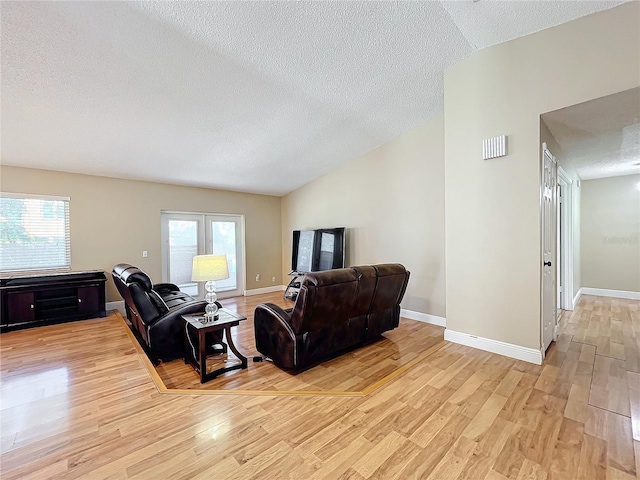 living room with lofted ceiling, light hardwood / wood-style flooring, and plenty of natural light