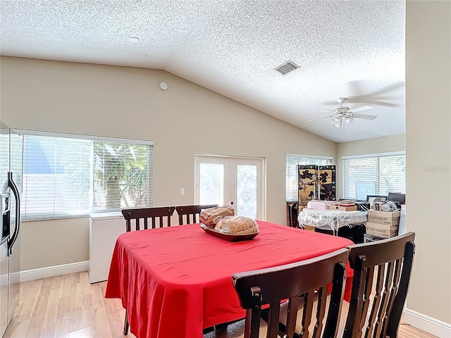 dining area featuring vaulted ceiling, light hardwood / wood-style floors, french doors, and ceiling fan