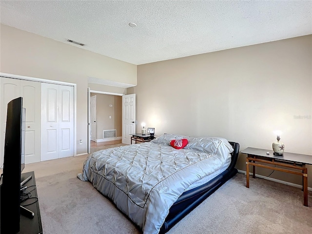 carpeted bedroom with a closet and a textured ceiling