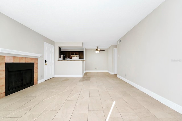 unfurnished living room with ceiling fan and a fireplace