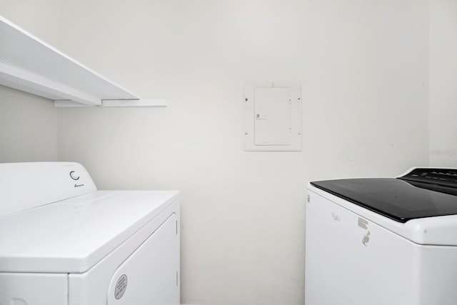 clothes washing area featuring electric panel and washer and clothes dryer