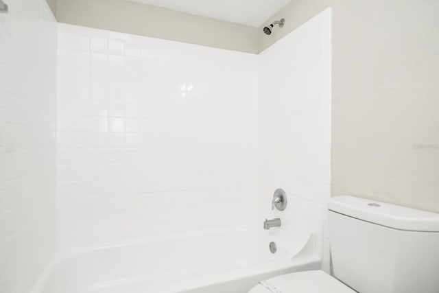 bathroom featuring tiled shower / bath and toilet