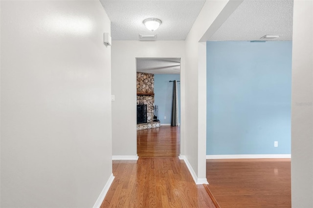 corridor featuring hardwood / wood-style flooring and a textured ceiling