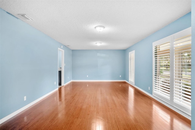 spare room with wood-type flooring and a textured ceiling