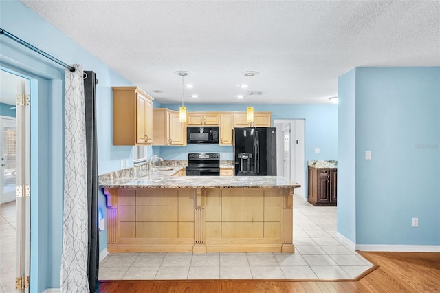 kitchen with pendant lighting, sink, black appliances, light brown cabinetry, and kitchen peninsula