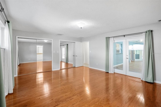 unfurnished room featuring hardwood / wood-style floors, a textured ceiling, and french doors