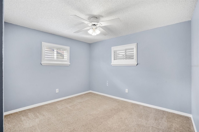 spare room with ceiling fan, carpet flooring, and a textured ceiling