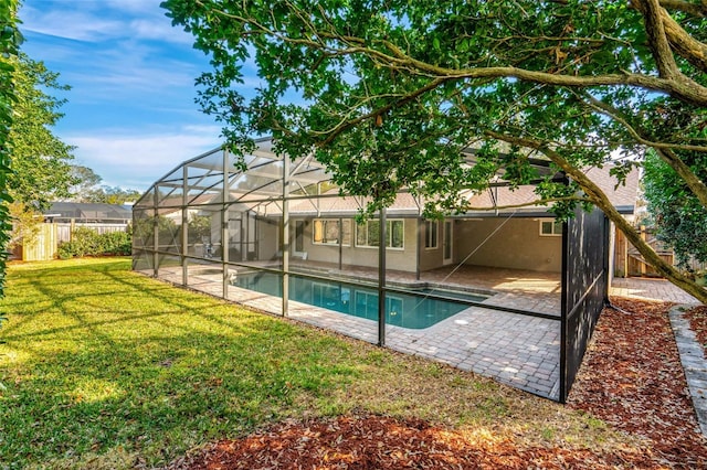 view of pool featuring a patio, glass enclosure, and a lawn