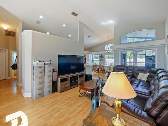 living room featuring high vaulted ceiling and light wood-type flooring