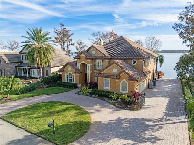 view of front of property with a water view, a garage, and a front lawn