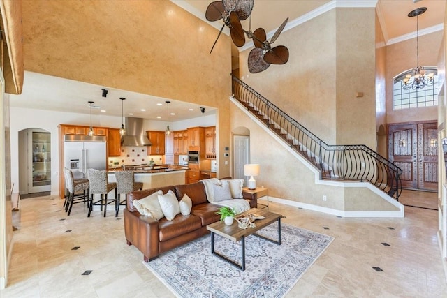 living room featuring crown molding, a high ceiling, and a notable chandelier