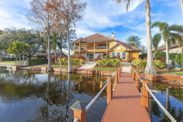 dock area with a balcony and a water view