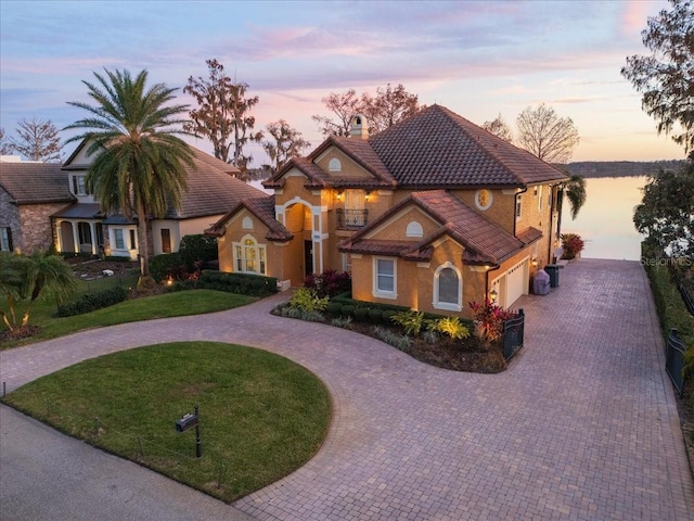 view of front of property with a yard, a garage, and central AC