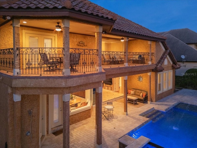 back of property featuring pool water feature, a balcony, ceiling fan, and a patio area