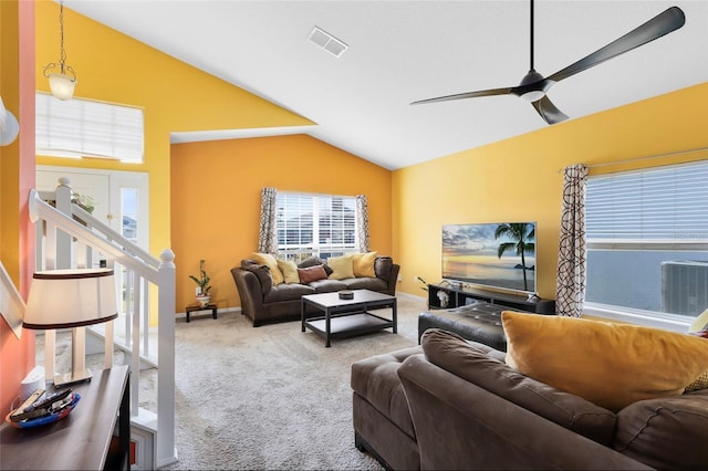 living room with carpet floors, a healthy amount of sunlight, and vaulted ceiling