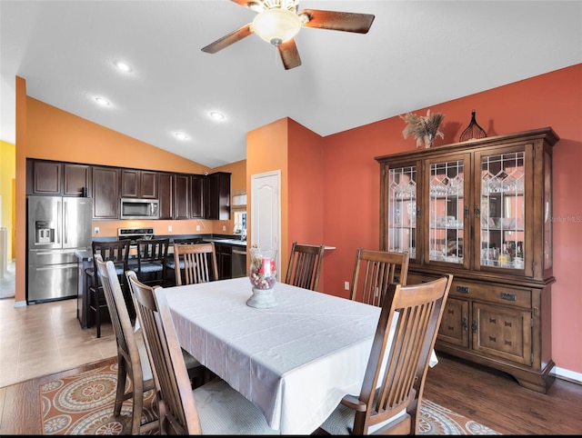 dining area with dark hardwood / wood-style flooring, vaulted ceiling, and ceiling fan