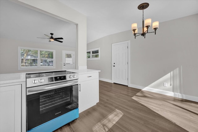 kitchen with lofted ceiling, stainless steel range with electric cooktop, decorative light fixtures, dark hardwood / wood-style floors, and white cabinets