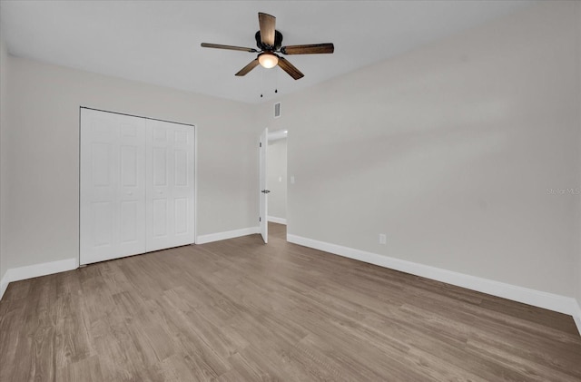 unfurnished bedroom with light hardwood / wood-style floors, a closet, and ceiling fan