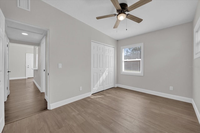 unfurnished bedroom featuring wood-type flooring, ceiling fan, and a closet