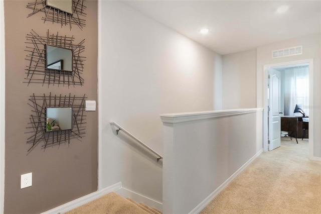 hallway featuring light colored carpet