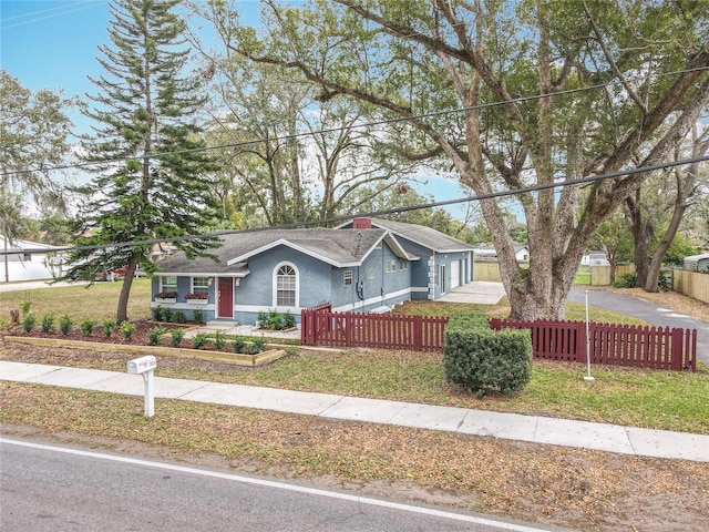 single story home featuring driveway, a front lawn, a fenced front yard, and stucco siding