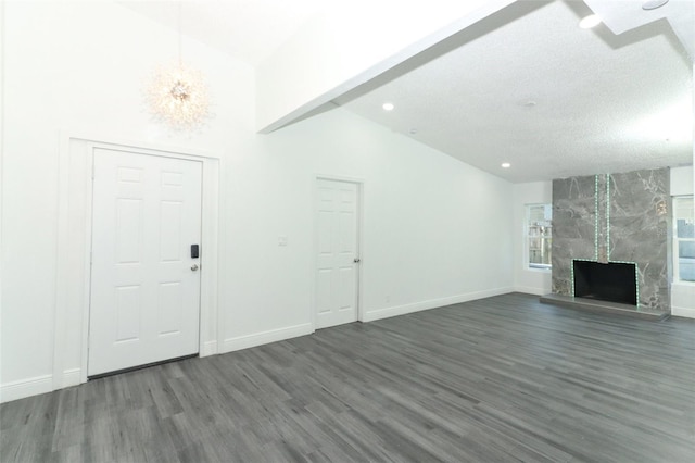 unfurnished living room featuring dark hardwood / wood-style flooring, high vaulted ceiling, and a premium fireplace