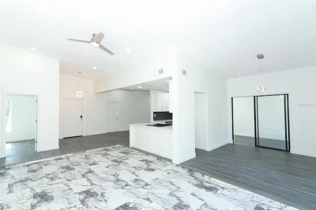 unfurnished living room featuring ceiling fan, dark hardwood / wood-style flooring, and high vaulted ceiling