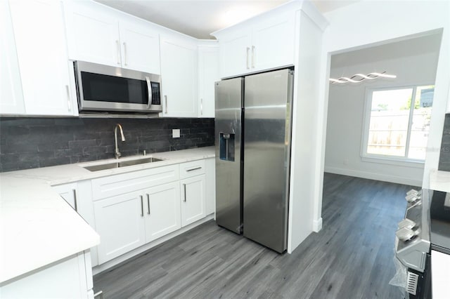 kitchen featuring white cabinetry, appliances with stainless steel finishes, sink, and decorative backsplash