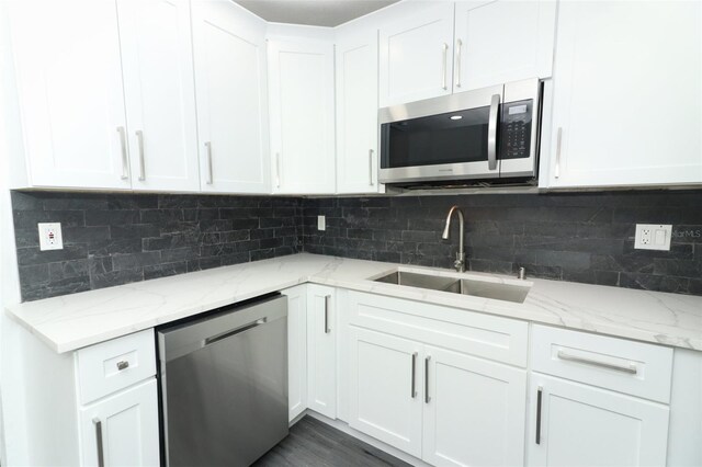 kitchen featuring light stone counters, appliances with stainless steel finishes, sink, and white cabinets