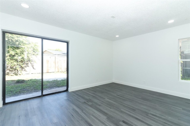 empty room featuring dark hardwood / wood-style flooring and a textured ceiling