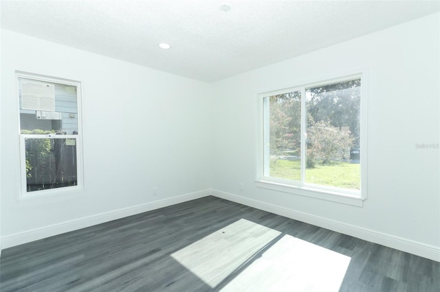 unfurnished room featuring dark hardwood / wood-style floors and a textured ceiling