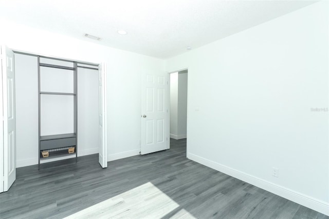 unfurnished bedroom featuring dark wood-type flooring and a closet