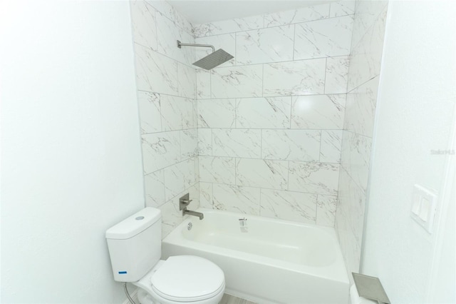 bathroom with tiled shower / bath and toilet