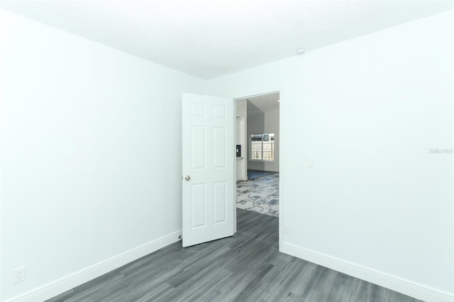 spare room featuring hardwood / wood-style flooring and a textured ceiling