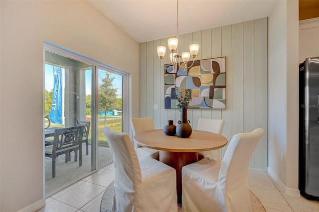 dining area with lofted ceiling, light tile patterned floors, and a notable chandelier